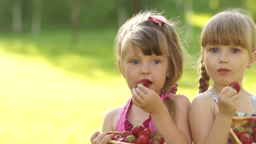 Happy kids eat strawberries
