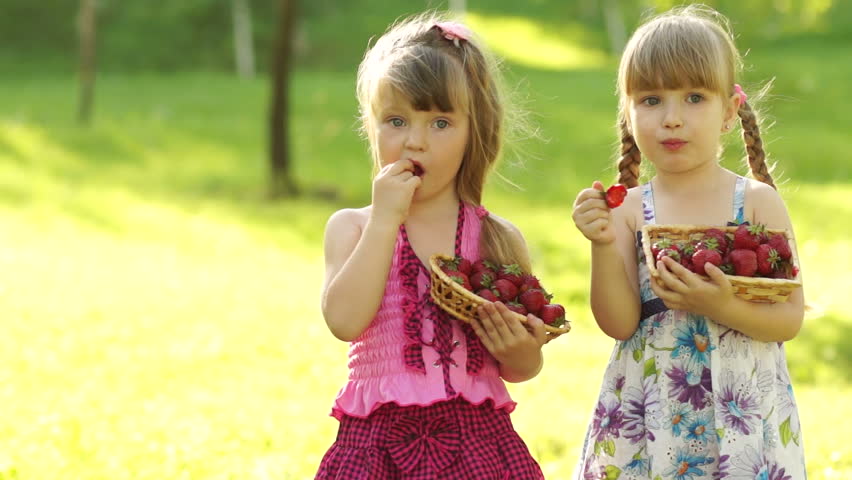 Funny children girl eating strawberries
