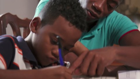 Happy black family at home. African american father and child. Latino dad helping son with school homework. Education and relationship, man teaching and boy learning
