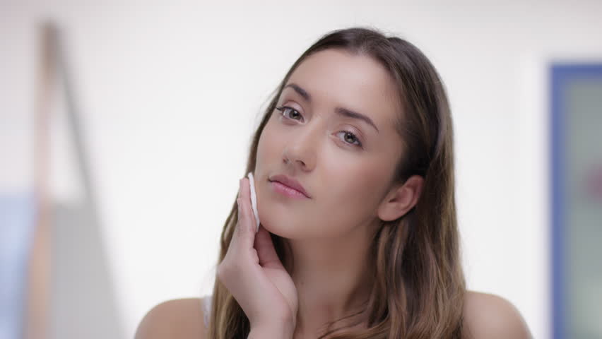 Young woman removes makeup with an cotton pad | Shutterstock HD Video #24153823