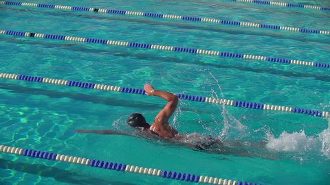Swimmer doing Front Crawl in Swimming Pool with lanes in Slow Motion.
