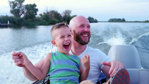 Father and son spend time together, emotionally respond during fast driving on speed boat, family on summer vacation, good dad at weekend with child