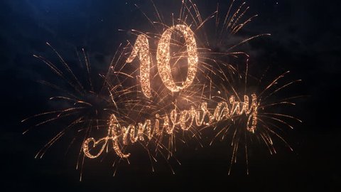 Happy birthday Anniversary 10 years celebration greeting text with particles and sparks on black night sky with colored slow motion fireworks on background, beautiful typography magic design.