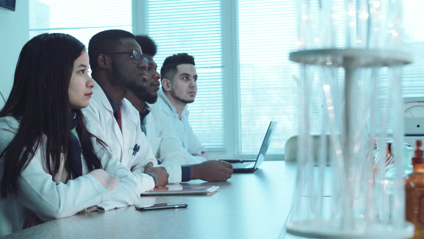 Group of young people students in white coats in chemistry lab listening the lector. Pharmacy classes concept. Footage with copy space Royalty-Free Stock Footage #24186526