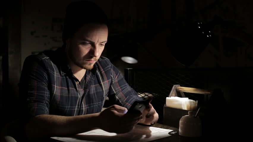 Man using smartphone in cafe in the night