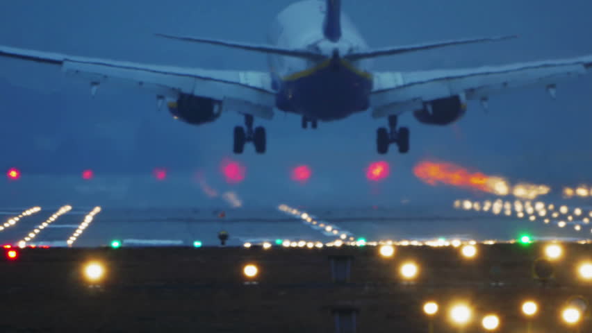 Commercial Jet Airplane Landing in airport runway at dusk, early night. 