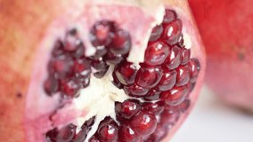 Halved red healthy Punica granatum close-up 4K 3840X2160 UHD tilting video - Lythraceae family pomegranate fruit with seedsslow tilt 2160p UltraHD footage