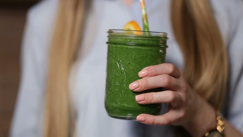 Woman drinking green detox vegetable smoothie