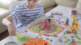 Boy experimenting with clay volcano.The boy is a creative game with volcanoes