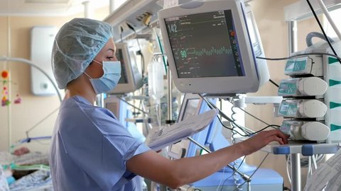 Doctor changes data on the monitor's screen in intensive care unit Stock Video