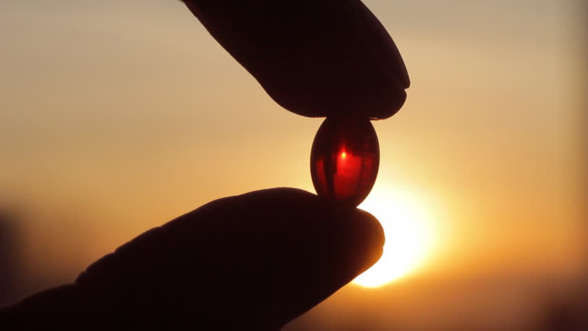 Men fingers holding magic red pill vitamin E capsule against sunset. Reality, medicine and pharmacy concept | Shutterstock HD Video #24210757