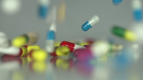 Raining Pills - Extreme close up of Medicine, drugs, pills, capsules falling in slow motion on a neutral background.