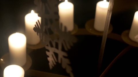 Advent white candles over that revolve decorations made of plywood depicting angels or Christmas trees 11p1
