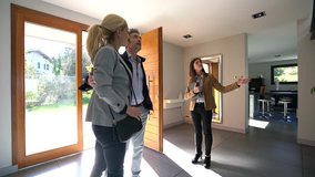 Real-estate agent presenting home to couple of clients