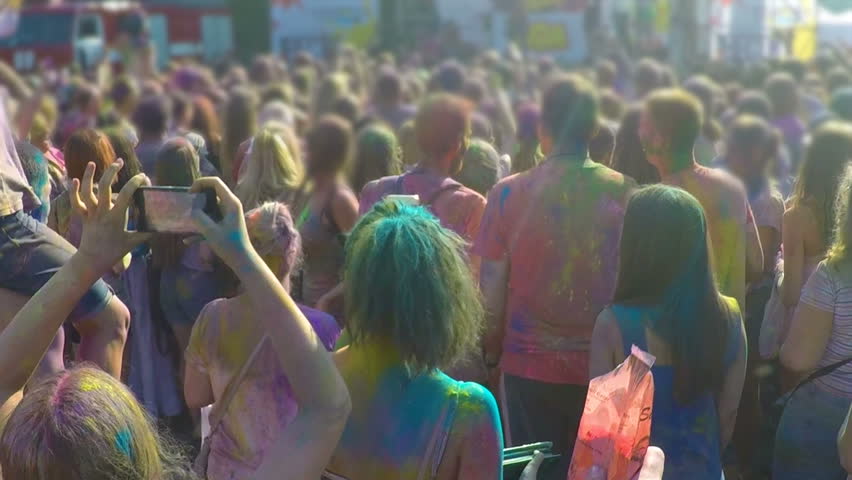 Many people throwing colorful powder in air together, having fun festival. Youth holding hands up, enjoying outdoor party atmosphere, togetherness. Positive crowd energy, happiness, entertaining music Royalty-Free Stock Footage #24228937