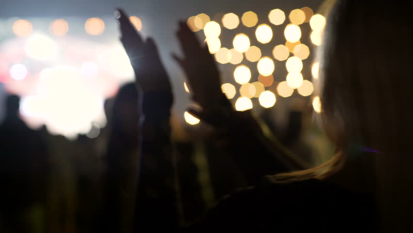 Party illumination, pretty blonde woman dancing and applauding at concert