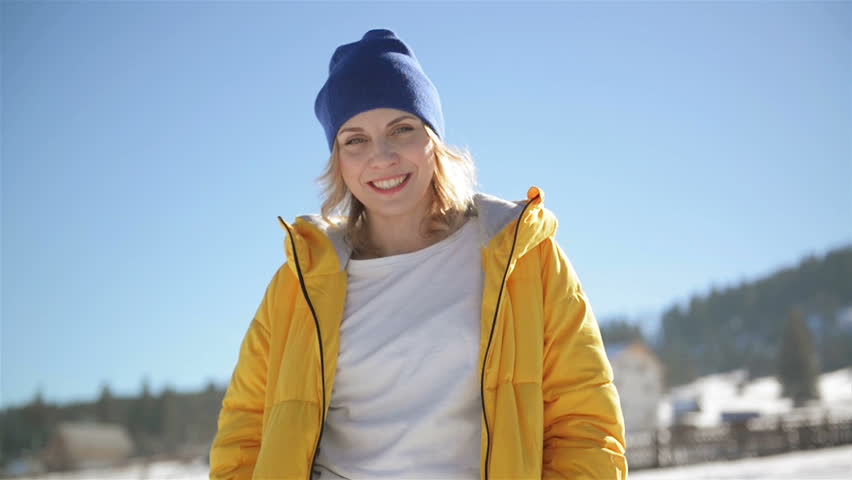 Smiling Woman is Enjoying Winter and Landscape of Countryside on Blue Sky Background. Outdoors Portrait of Young Amazing Lady with Charming Smile.