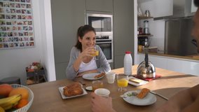 Couple having breakfast in home kitchen