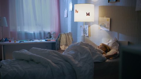 Young Loving Mother Tucks in Her Cute Little Daughter and Turns Off the Light. Shot on RED EPIC-W 8K Helium Cinema Camera.