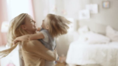 Beautiful Happy Young Mother Holds Her Cute Little Daughter in Her Hands and Spins With. Both are Laughing. Shot on RED EPIC-W 8K Helium Cinema Camera.