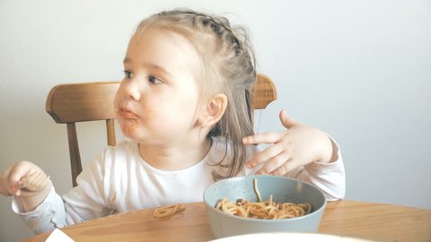 Cute little girl having problems with spaghetti