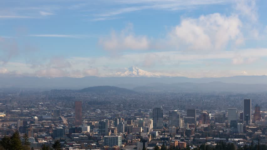 Ultra high definition 4k time lapse movie of clouds and blue sky over snow covered mount hood and downtown cityscape of Portland Oregon one winter morning 4096x2304 uhd