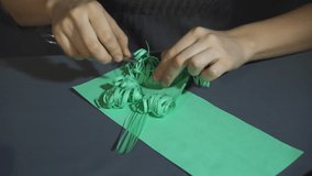 Graceful female hands gently slicing into thin strips the green paper with metal scissors over the gray table closeup. - Powered by Shutterstock - Get 15% off with code: PIKWIZARD15