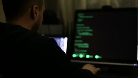 Hacker working at night, trying to break into system, cybercrime