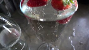 Strawberries floating on soda water, HD slow motion