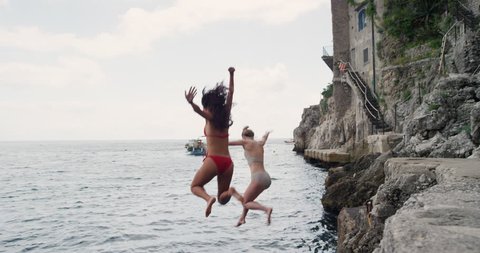 Happy Friends jumping into ocean together having excitement freedom fun action healthy travel vacation adventure Amalfi Coast Italy