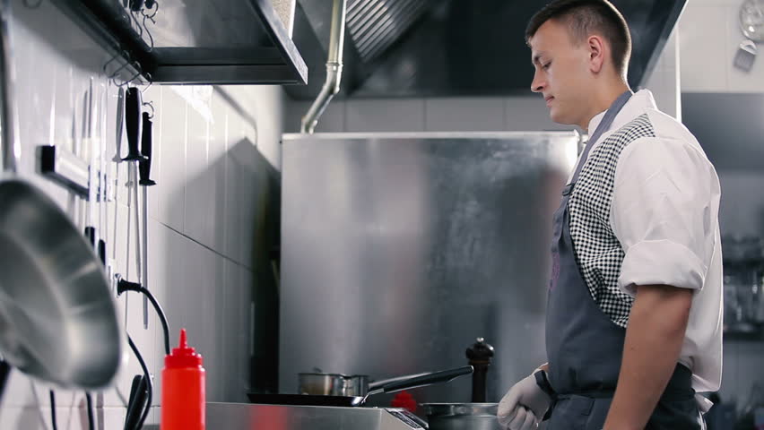 Young man preparing pancakes at a restaurant.