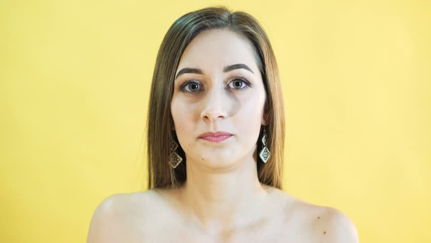 Portrait of thinking woman on yellow background. 4K