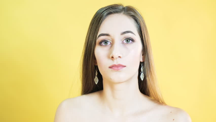 Cute woman with emotion of corageous on yellow background 4K