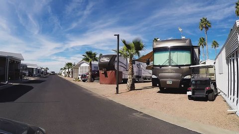 APACHE JUNCTION AZ/USA: February 16, 2017- Driving past recreational vehicles in an RV resort. Large mobile homes and buses for travel lifestyle are seen positioned in orderly rows on street.