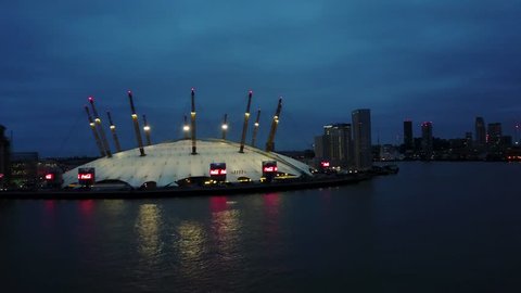 Aerial/Drone footage of the London's O2 arena (Millenium dome) and the river Thames at night. (4K)