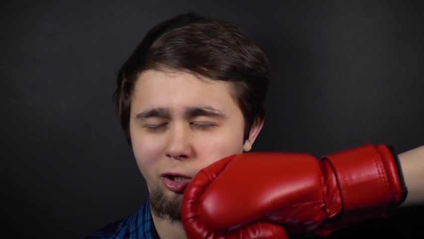 Punch red boxing glove in face man. Slow motion.