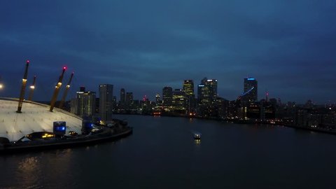Aerial/Drone footage of the London's O2 arena (Millenium dome) and the river Thames at night. (4K)