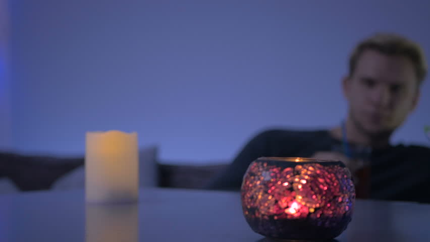 Close-up - the man on blurred background smoking a hookah in cafe