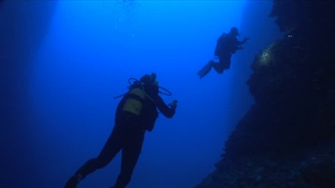 scuba divers exploring a cave underwater cave dive