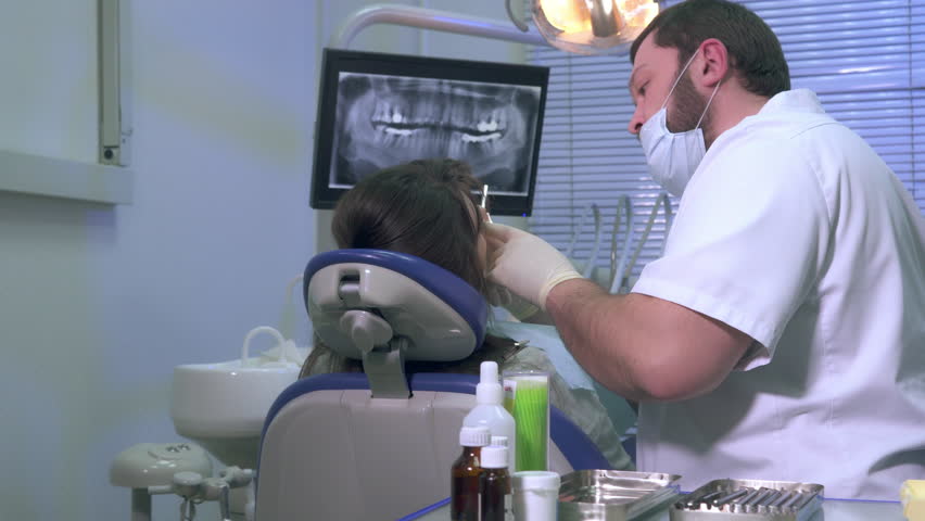 Dentist at work shows a patient x-ray images of teeth | Shutterstock HD Video #24305384