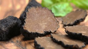 a circular motion around the black truffle chopped in slices