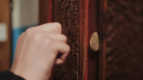 Close-up of hand knocking on door