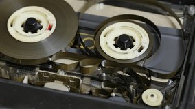 Tape loops and tangling in a deck cassette player when the take up spool stops or running slower than the other. Close up 4K static shot. Audio cassette tape in use sound playback
