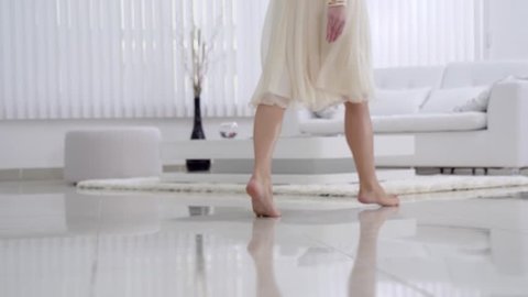 Beautiful young girl bare feet moving on interior in the living room in slow motion. View of young girl elegantly to walk.Sexy legs. Floor. Gait. Slow motion family home part 6 of 15.