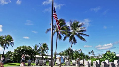 American Flag at Pearl Harbor base in Honolulu Hawaii, always half-mast in respect of victims. historic landmark, patriotic symbol and memorial of the Japanese attack in WW II. tourist taking pictures