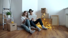 Young couple moving in new home.Sitting on floor and relaxing after cleaning and unpacking.Using tablet. - Powered by Shutterstock - Get 15% off with code: PIKWIZARD15