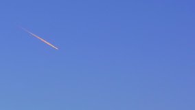 Jet plane flies in the blue sky, leaving a vapor trail. (av35733c)