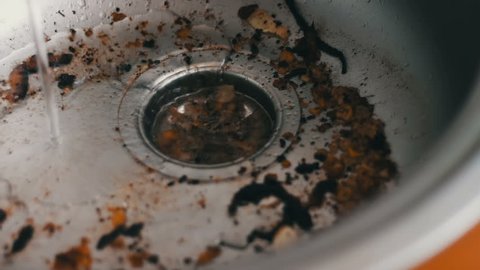 Dirty clogged sink by various food scraps and fat close up view