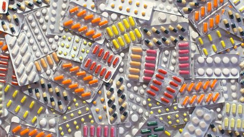 Closeup shot of pills removed. Healthcare industry concept. Pharmaceutical, medical capsules removing from table. Drug components, medical product pellet capsules. Clearing pills of different vitamins