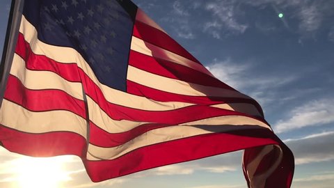 American flag flying in the wind at sunrise slow motion